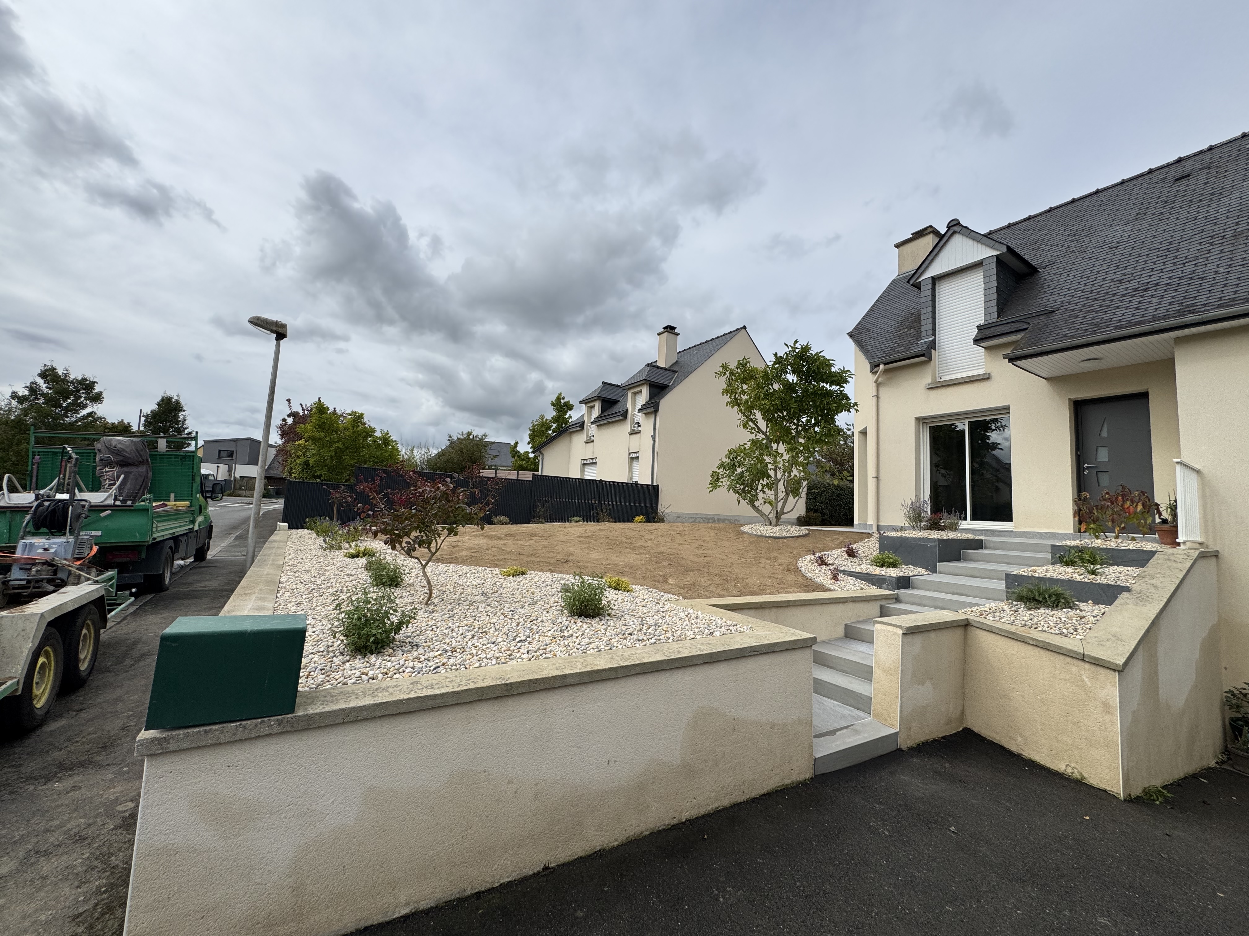 Aménagement extérieur avec gazon, massifs minéraux, escalier et plantations